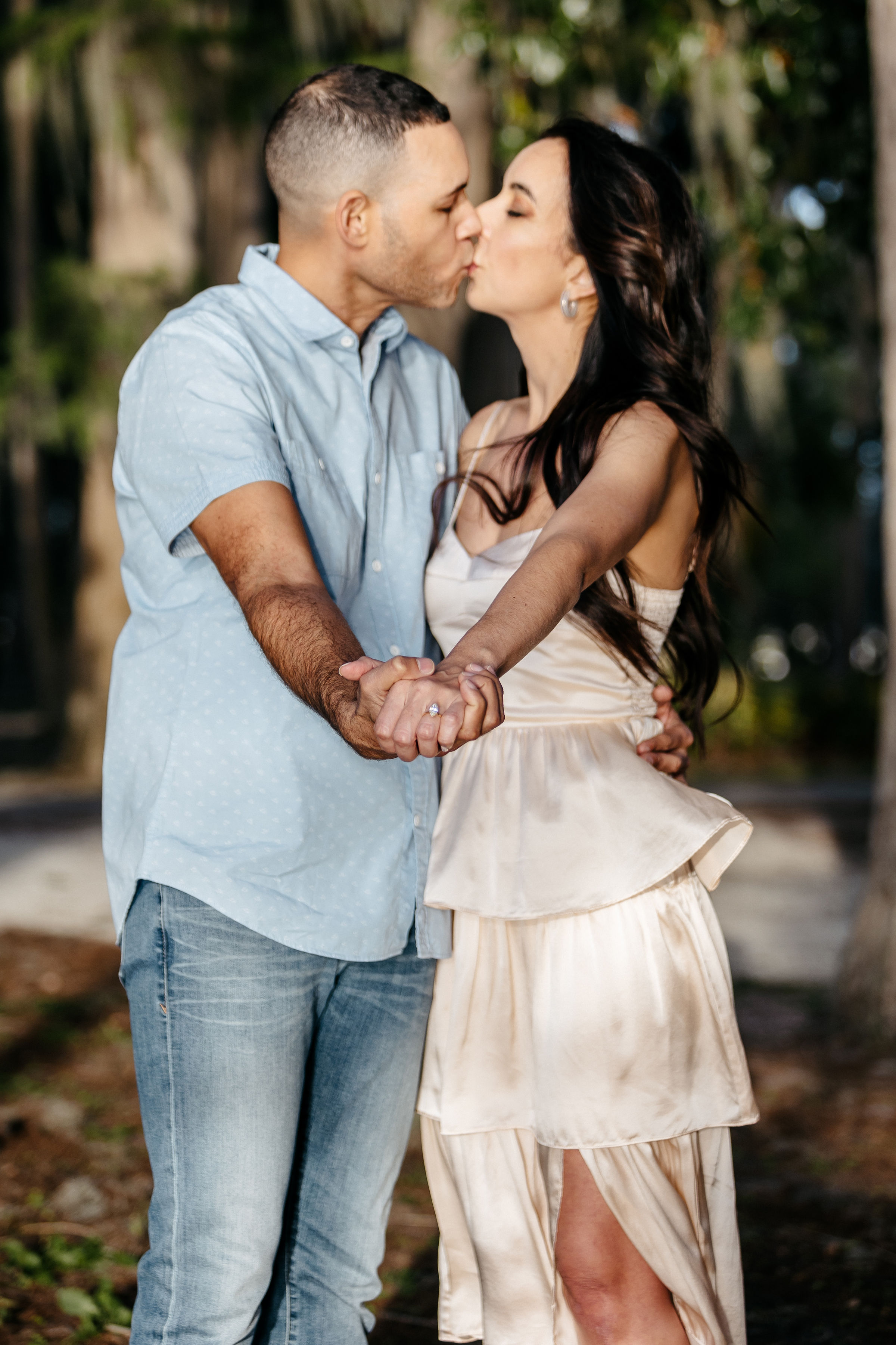 A man and a woman are kissing and showing the engagement ring | Engagement Photography