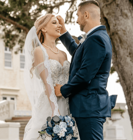 Newlyweds smiling together beside a large tree during their Tampa wedding