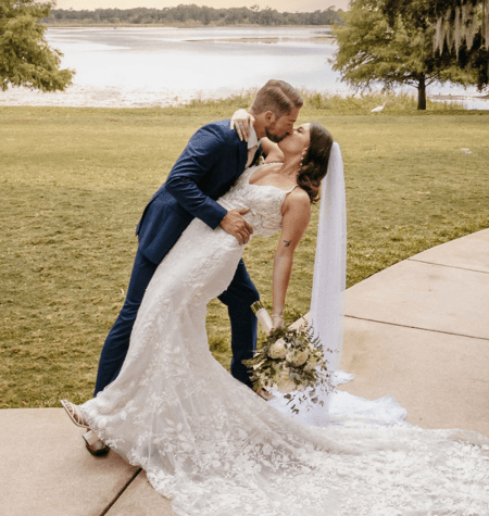 Groom dipping the bride beside the water during an outdoor Tampa Bay wedding