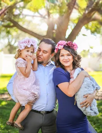 Florida photographer Roy smiling with his wife and two young daughters outdoors