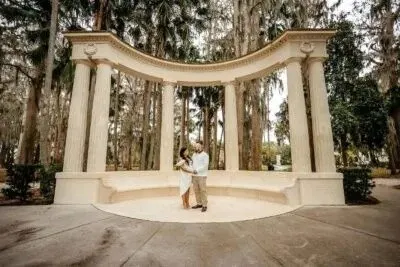 Couple beneath the stone exedra at Kraft Azalea Garden in Winter Park