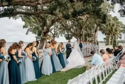 Bride and groom exchanging vows beneath moss-covered trees during an outdoor wedding ceremony in Florida.