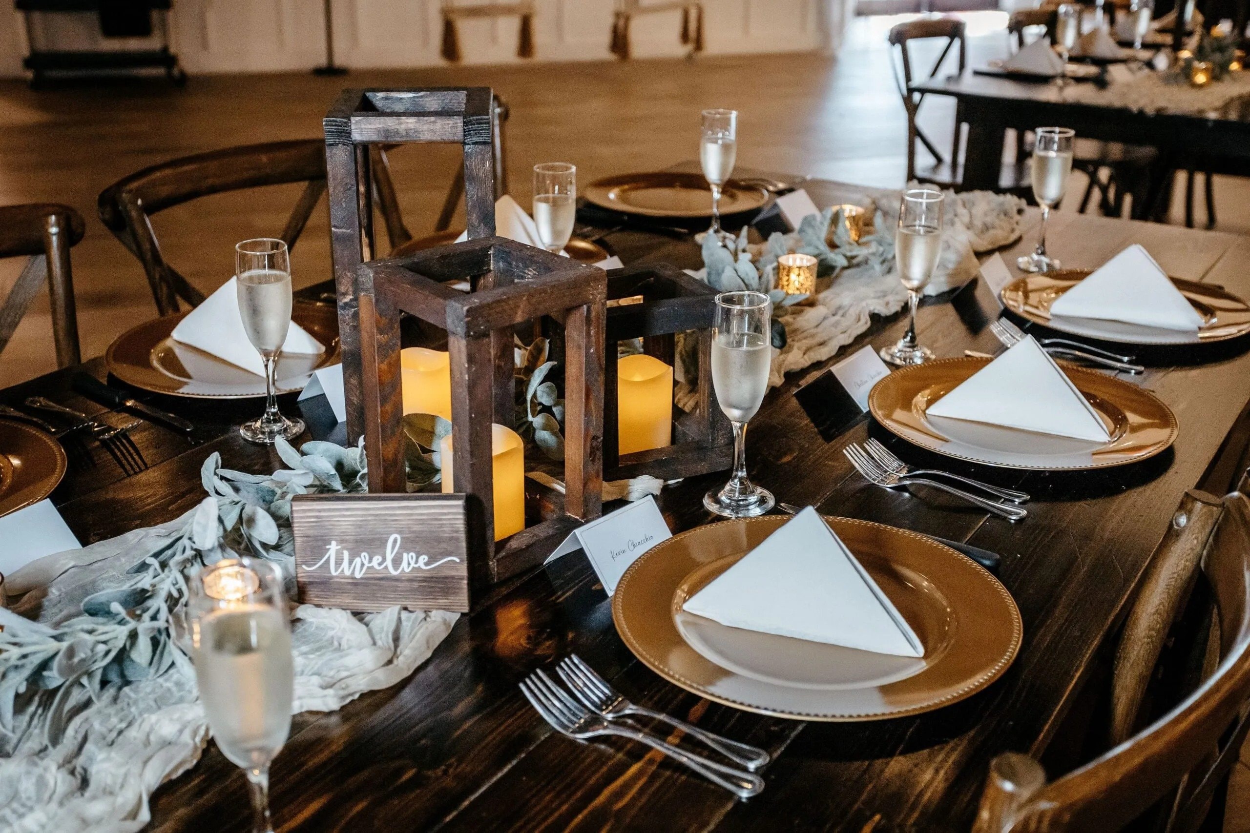 Elegant wedding reception table with candles, champagne glasses, and place settings photographed by a Florida wedding photographer.
