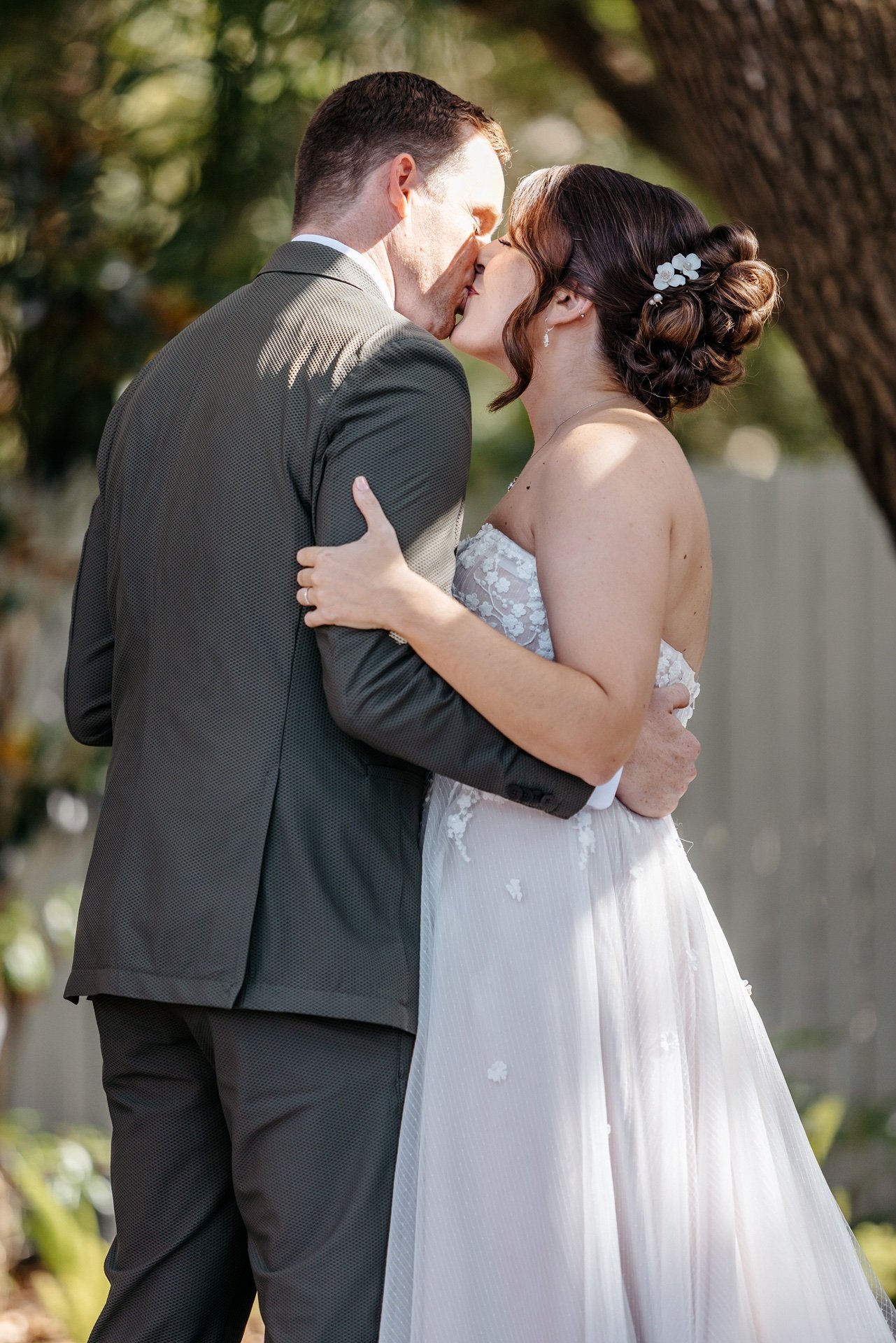 A groom kisses his bride after saying their vows in front of family at their wedding in Central Florida