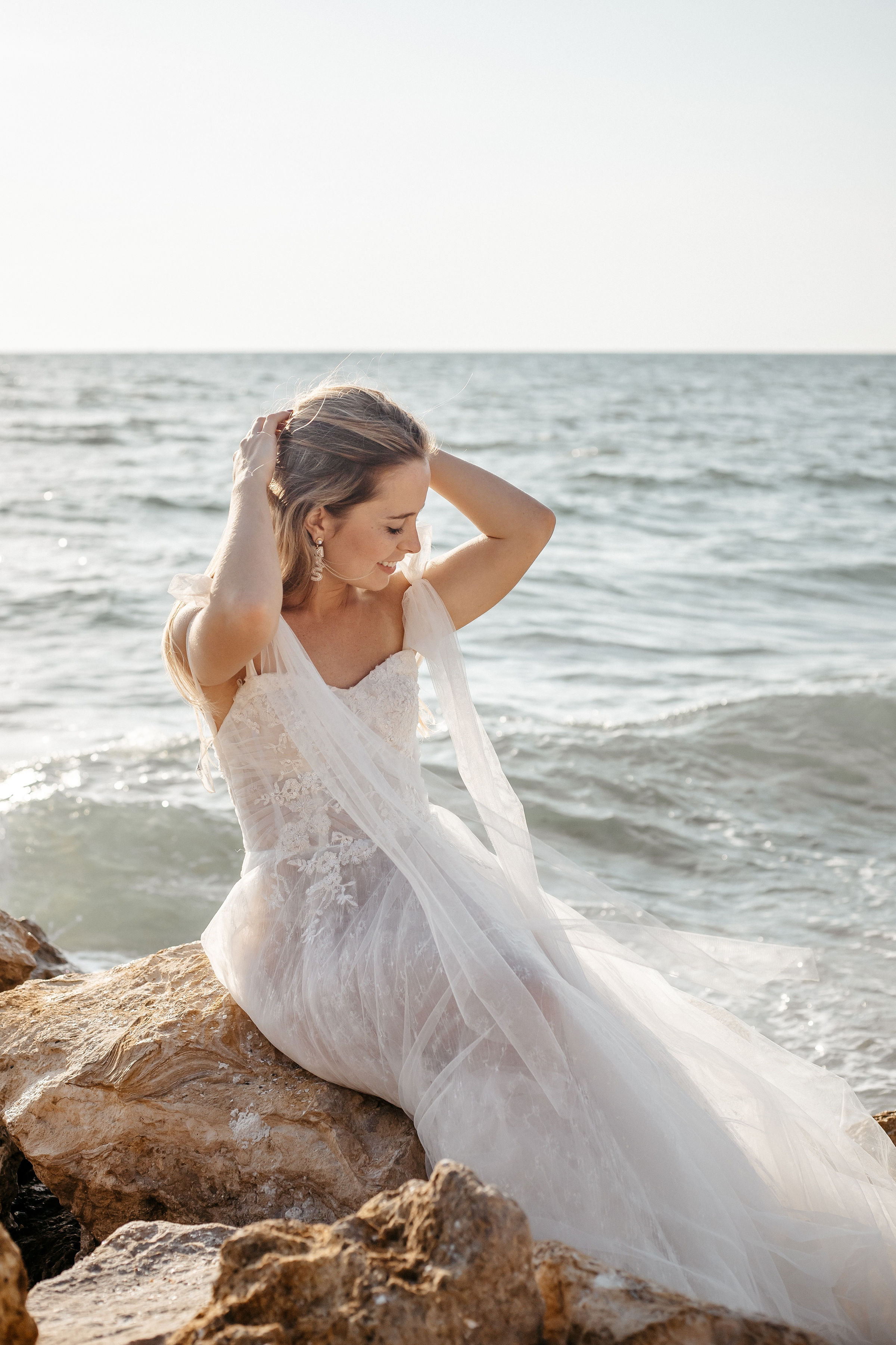 A bride posing on a sea rock for wedding photography | Cherished memories studio