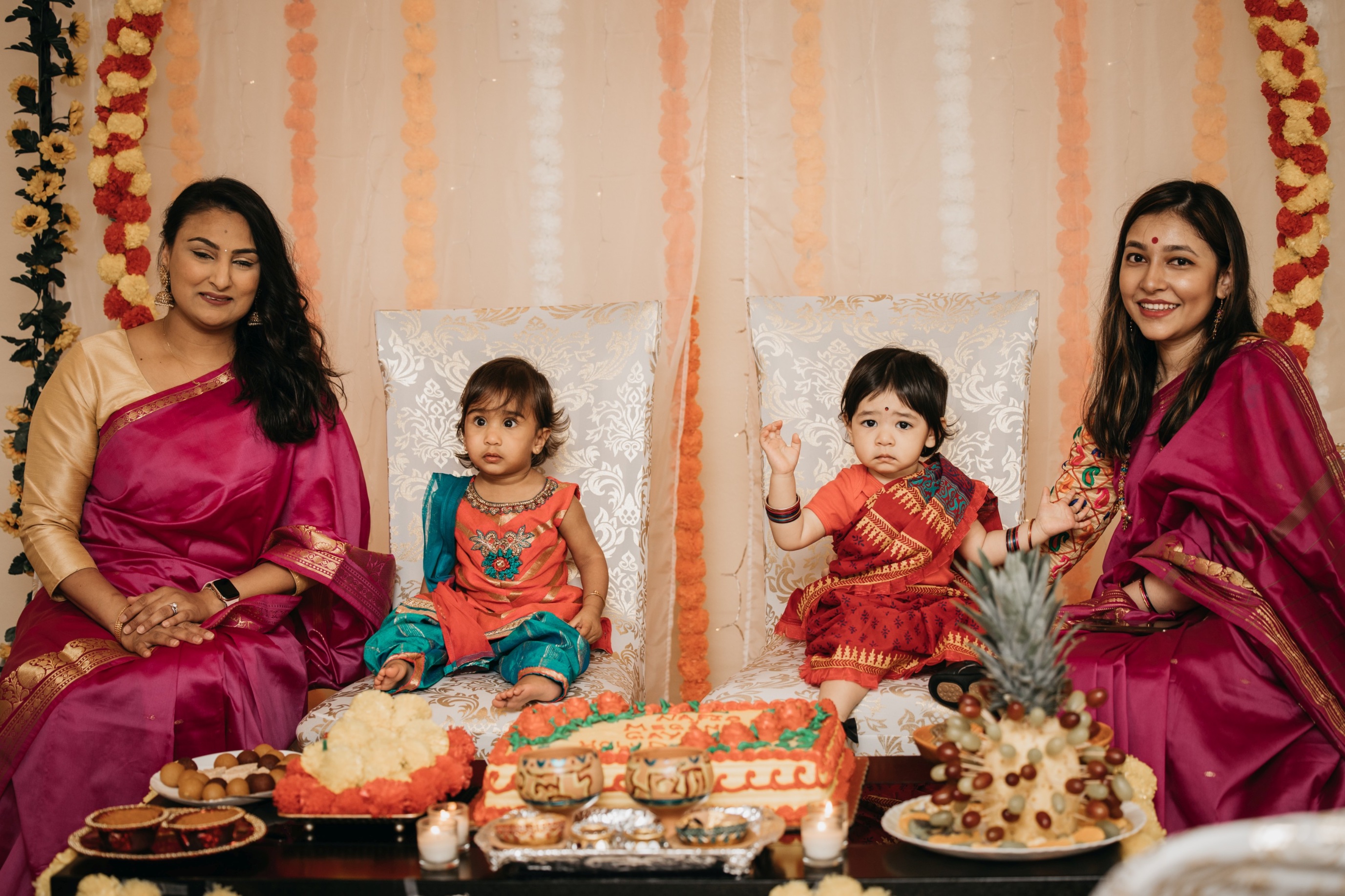 Two women and two babies dressed in reds and purples smile while enjoying their family member's 520 on the water wedding