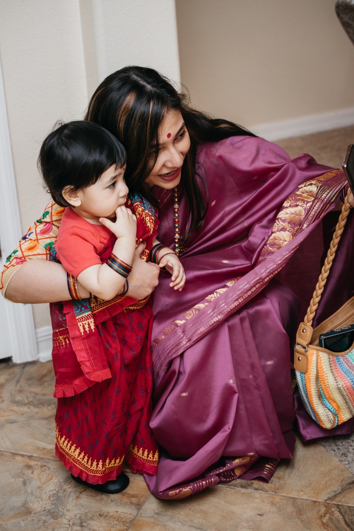 A mother in a purple dress and a baby in a red dress look across the room at services offered by 520 on the water