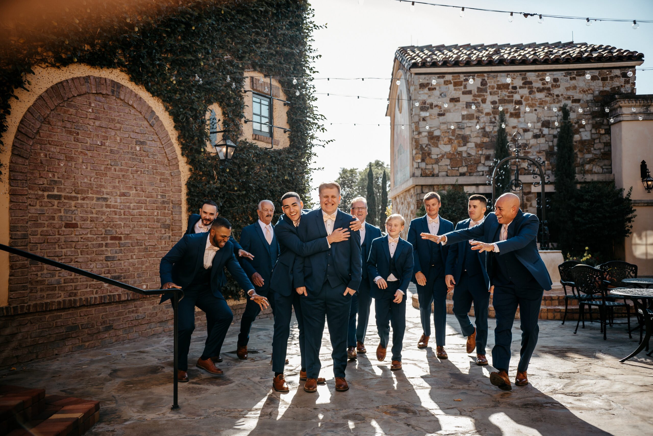 Groom celebrates with his groomsman in blue suits outside the hotels near Bella Collina Orlando