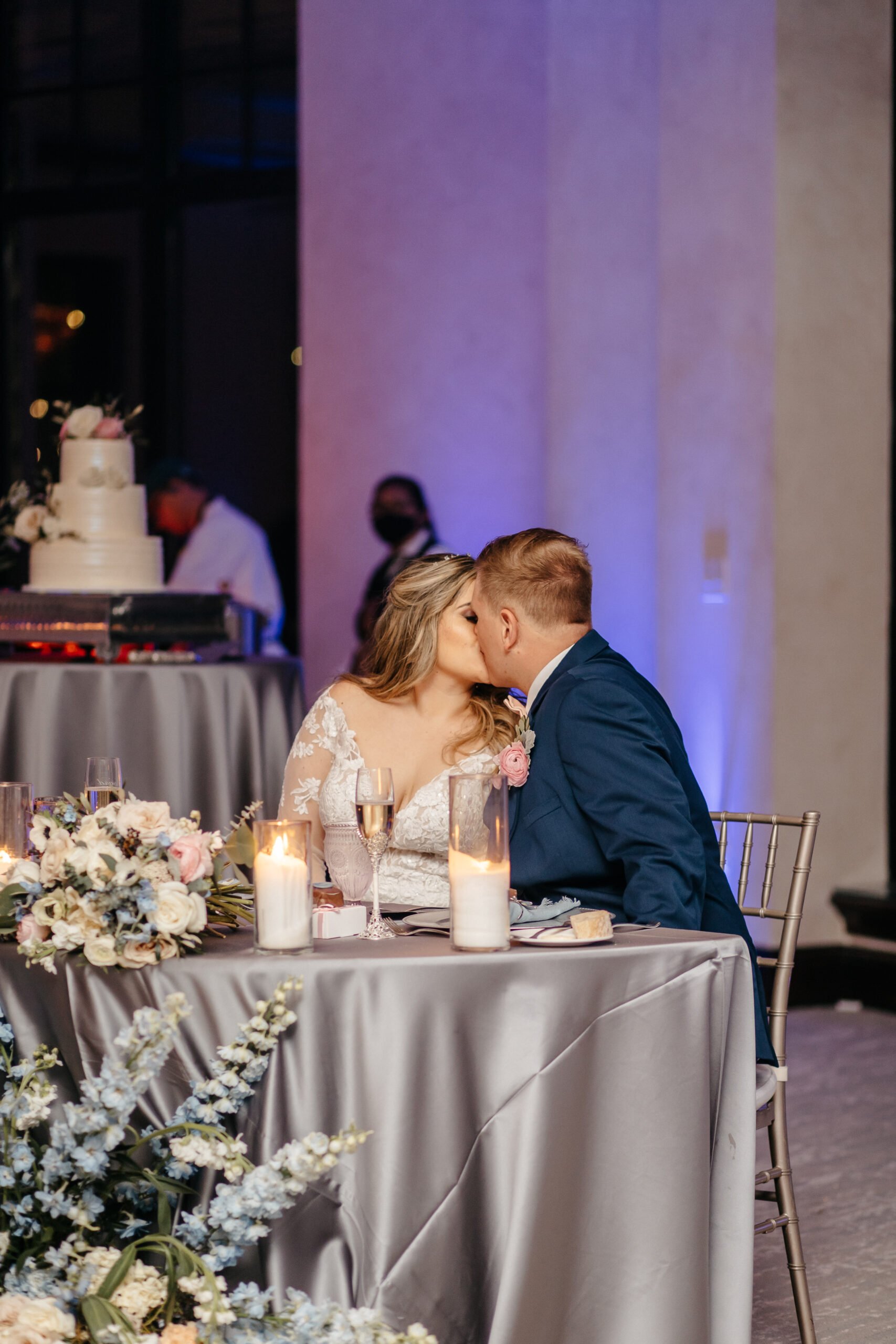 Bride and groom share a kiss at their beautifully decorated table at their reception in Bella Collina Orlando FL