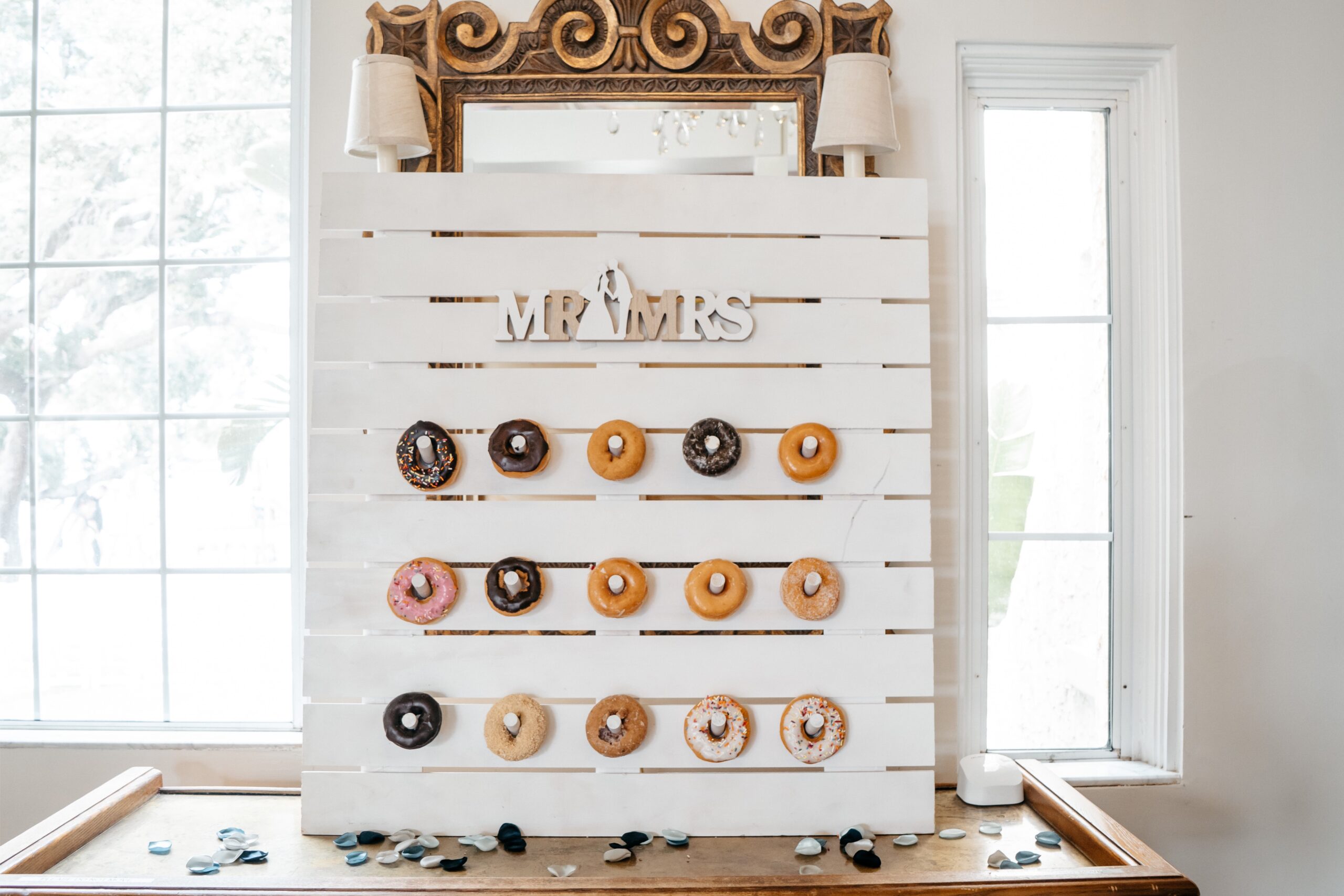 Central Florida wedding videographer takes photos of a donut board for guests decorated with a variety of donut types