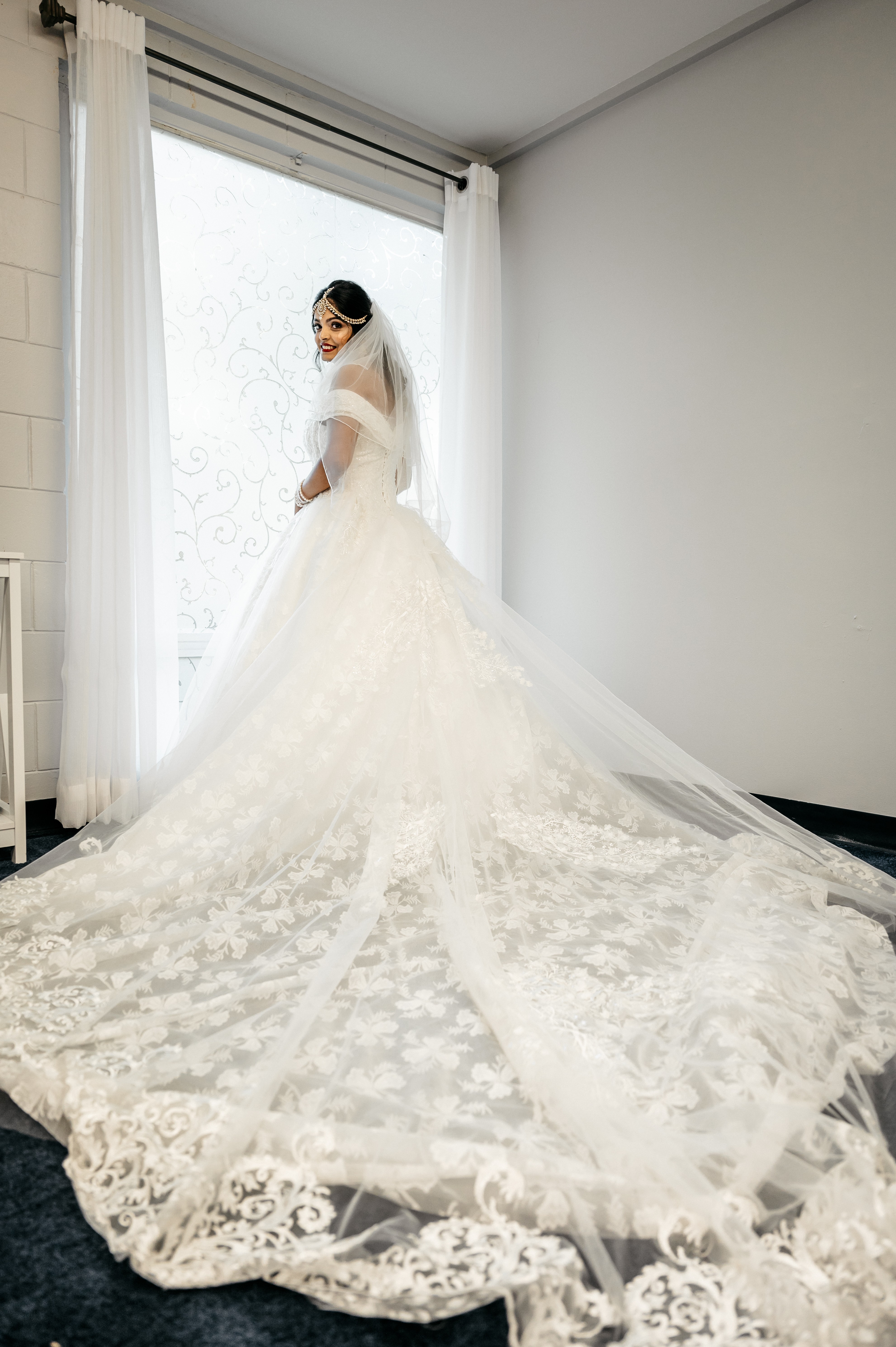 A beautiful bride in a white wedding gown looks back at the photographer at altamonte wedding chapel