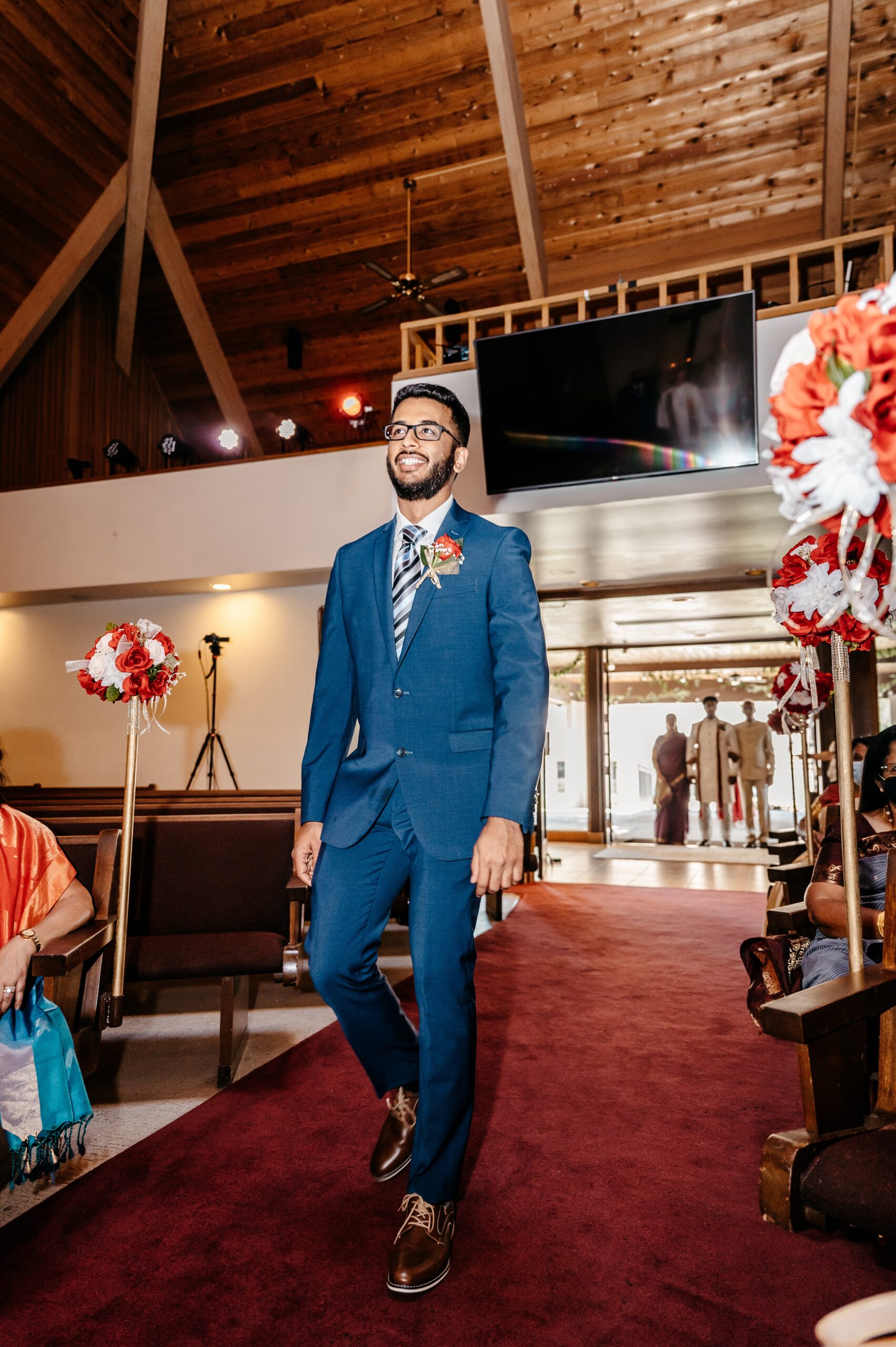 Groomsman walks down the aisle on a burgundy carpet at altamonte chapel wedding