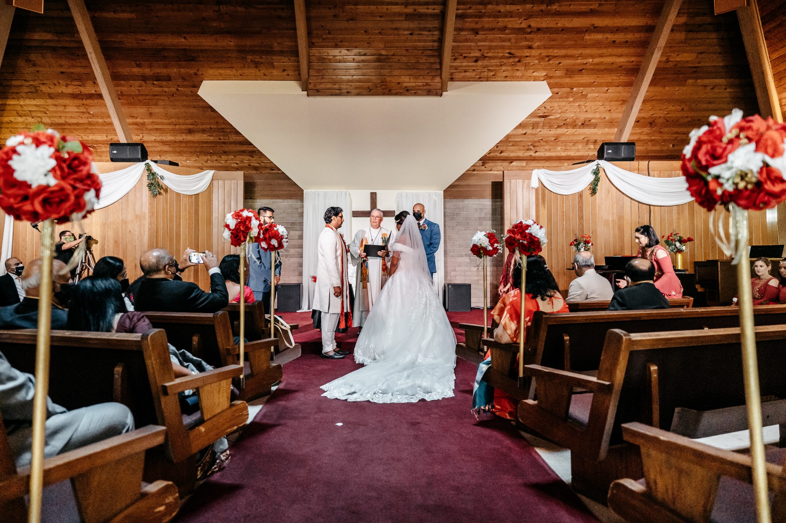 A bride and groom stand at the altar and listen to the priest speak at the
altamonte wedding chapel