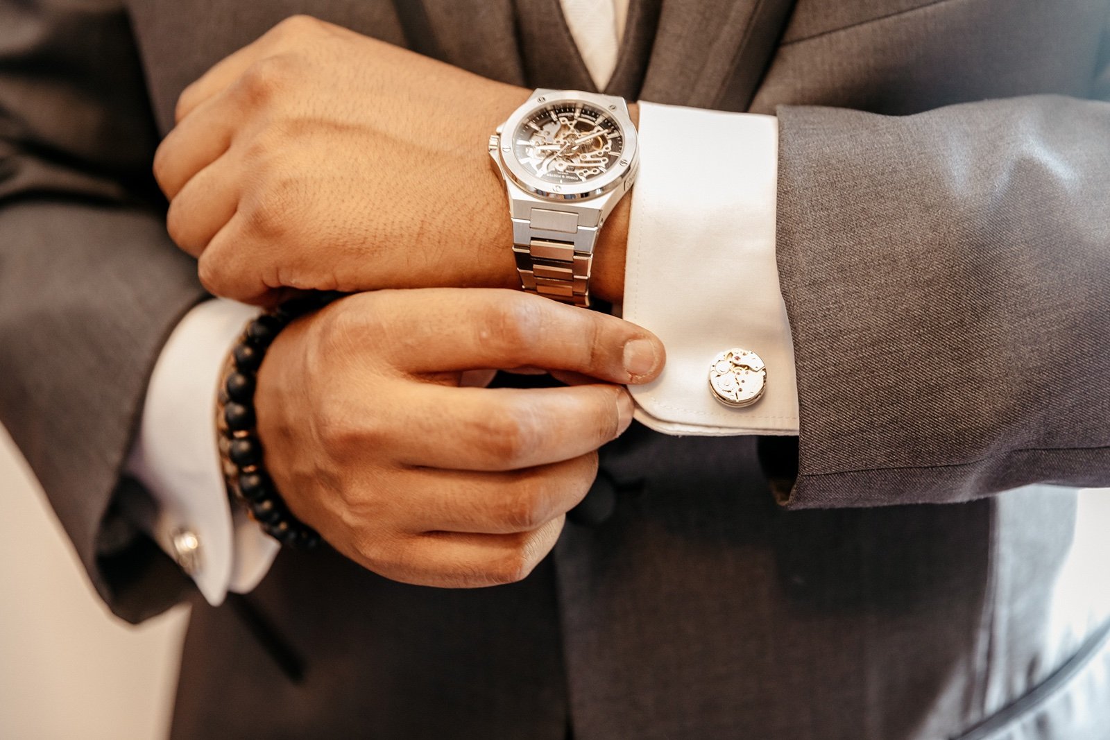 A groom fixes his sleeves and cufflinks as he prepares for his bella cosa wedding