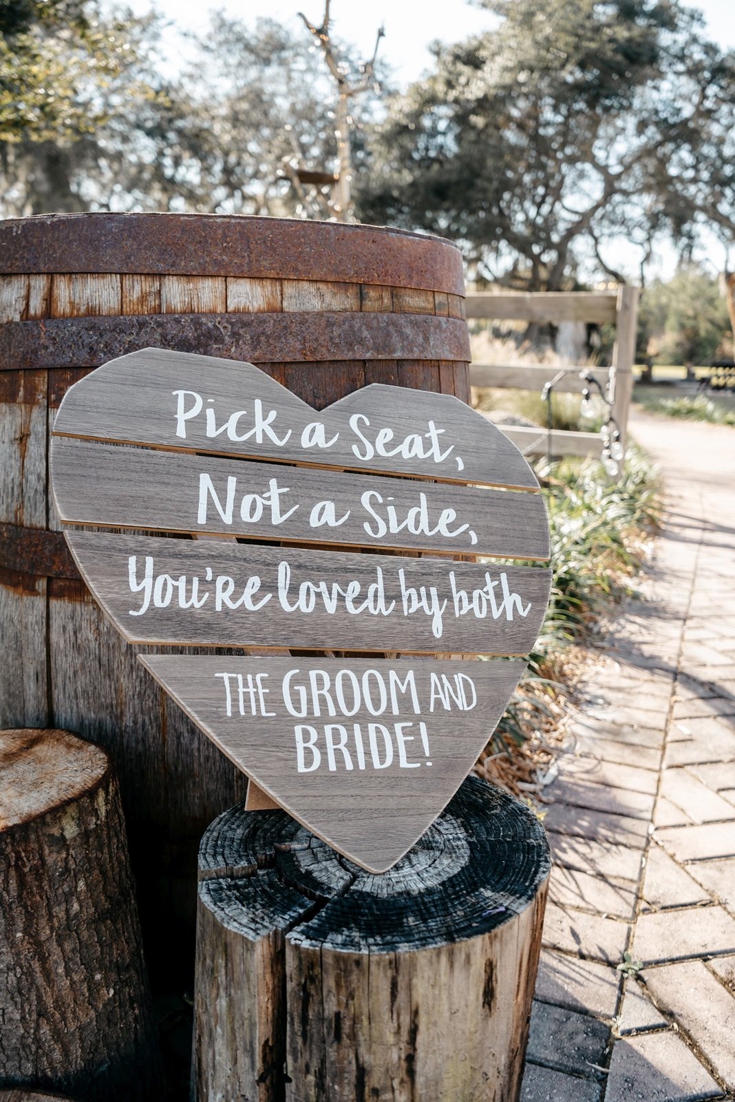 A welcome sign in front of a wooden barrel sets out to show guests the entrace to outdoor wedding venues in central florida