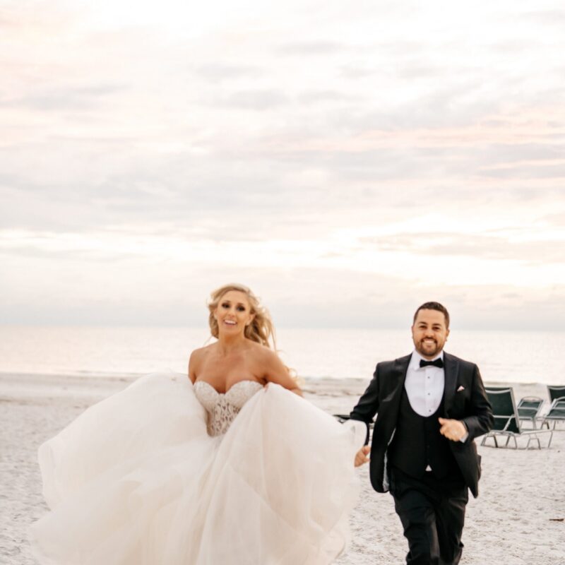 Bride and groom walking together along the beach during their Florida wedding