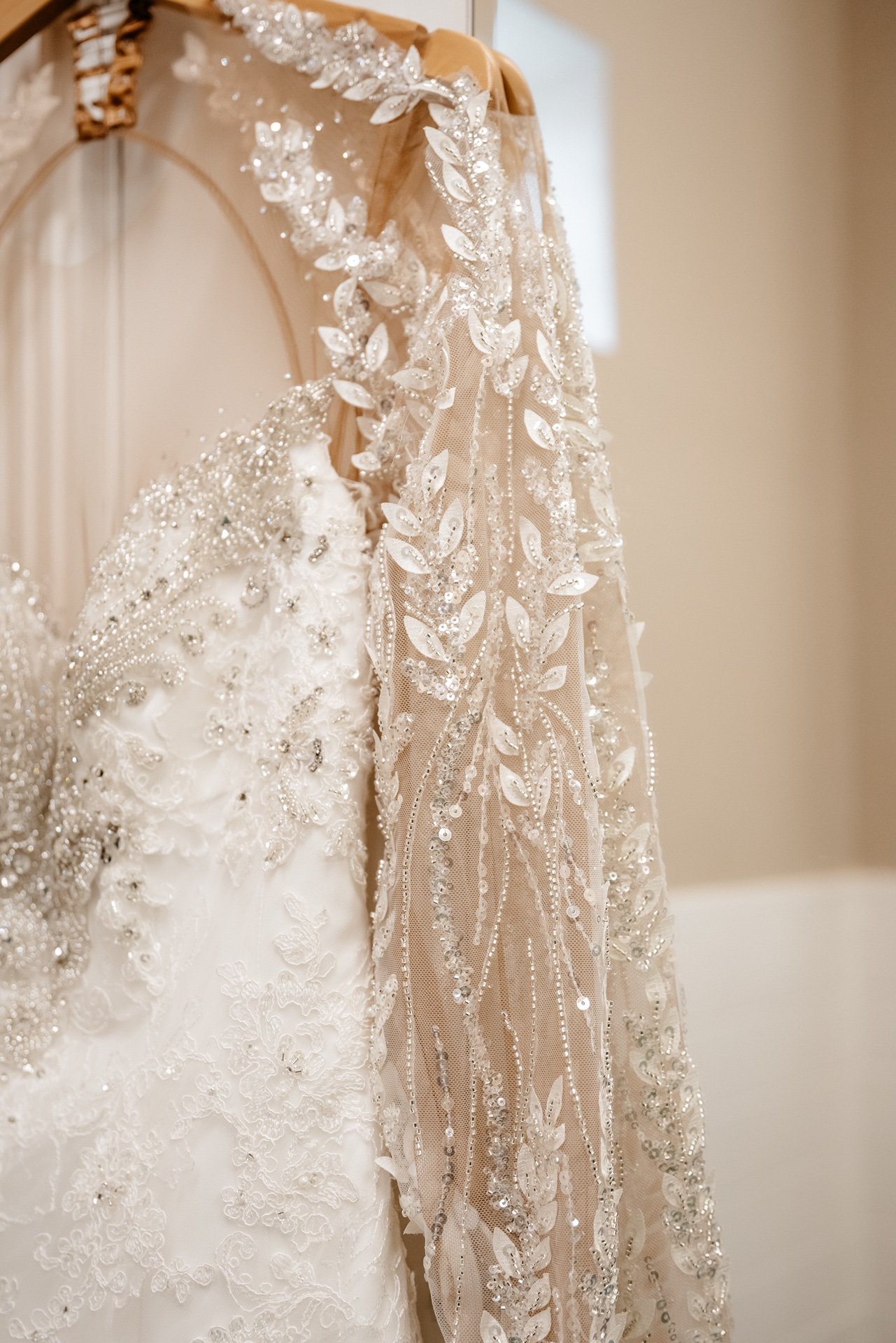 A lace wedding dress covered in gems is displayed for photos before the ceremony at a wedding venue in Florida