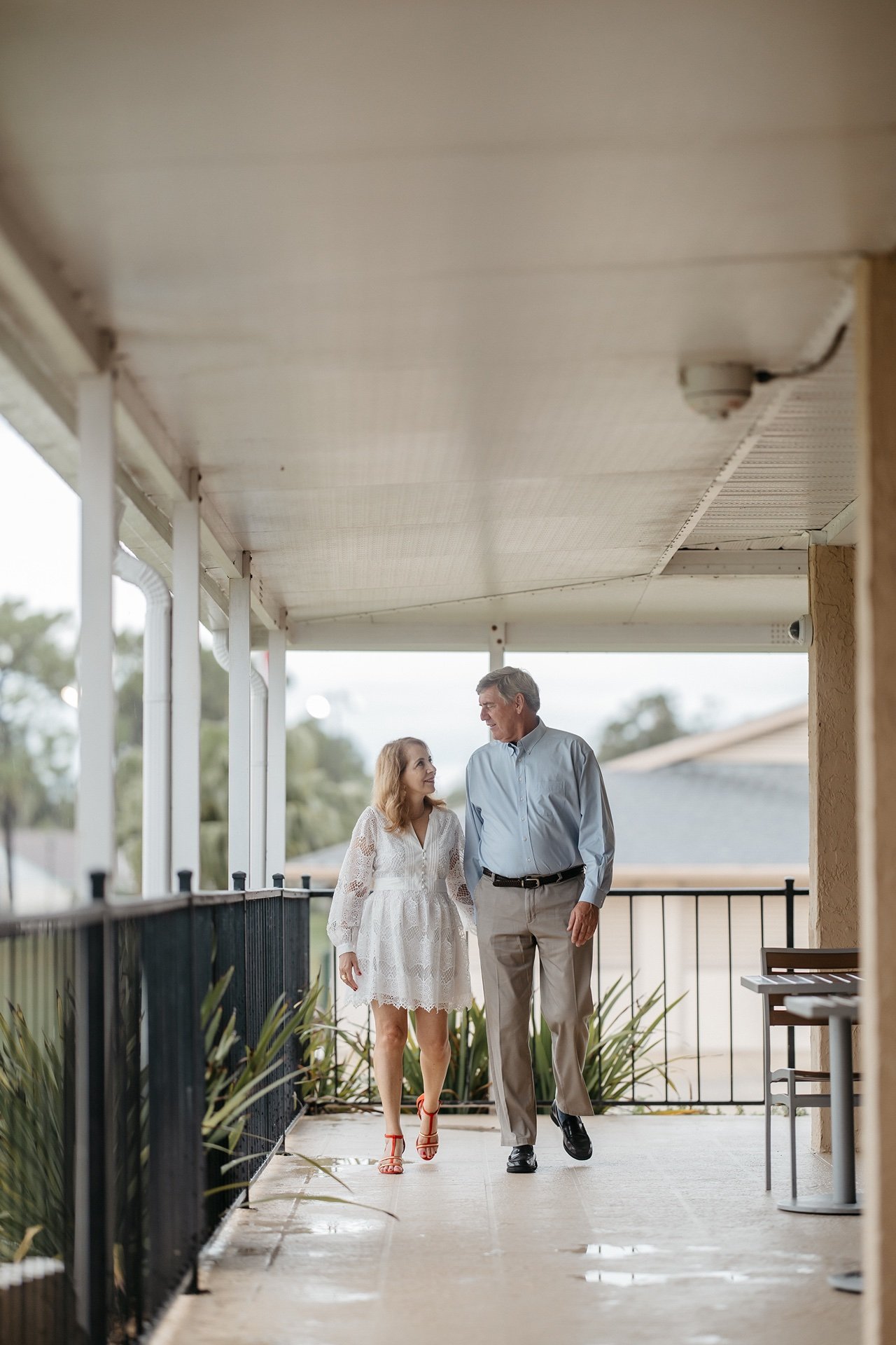 Husband and wife walk down a porch in Central Florida after their wedding