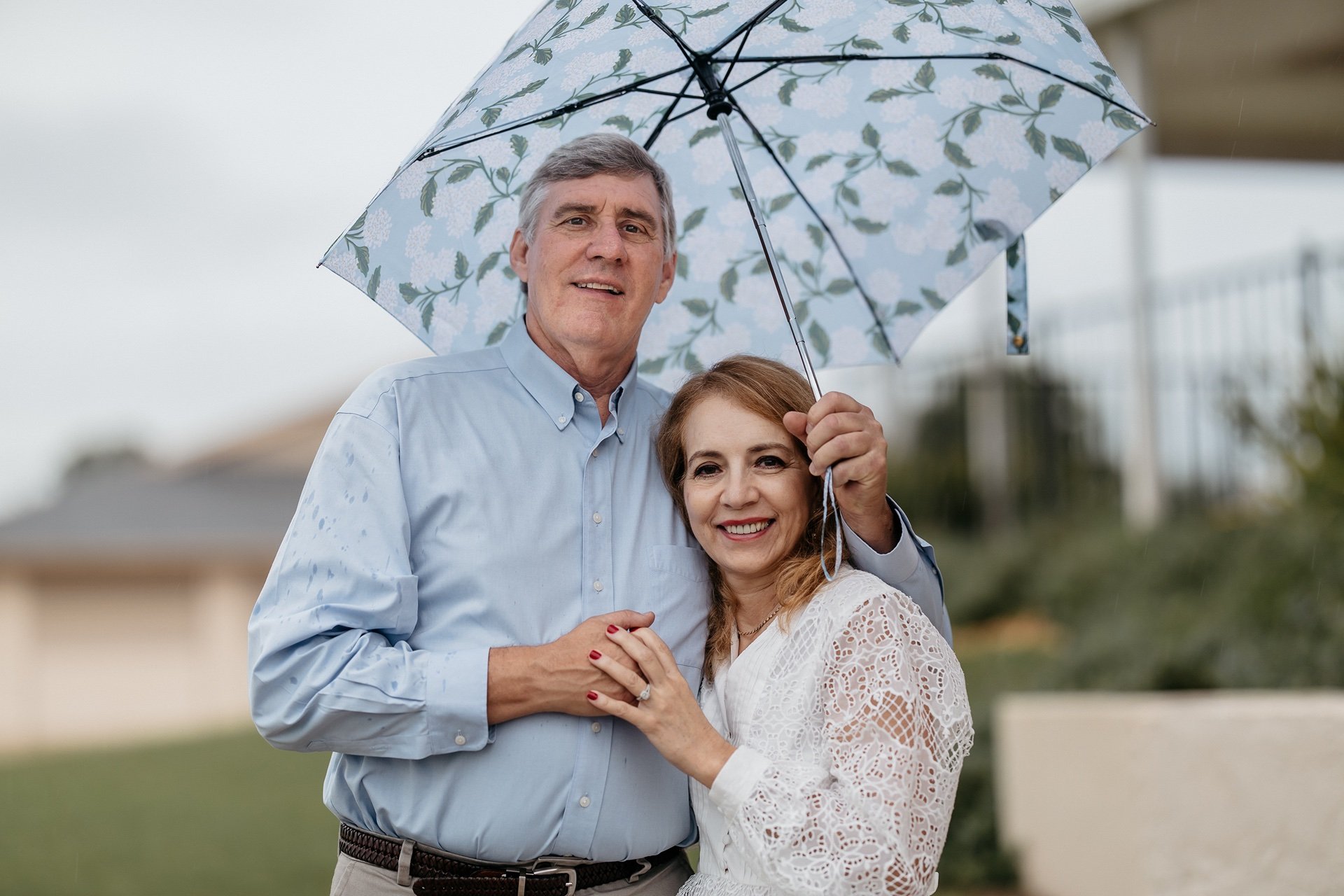 Bride and groom stand under umbrella at their Central Florida wedding