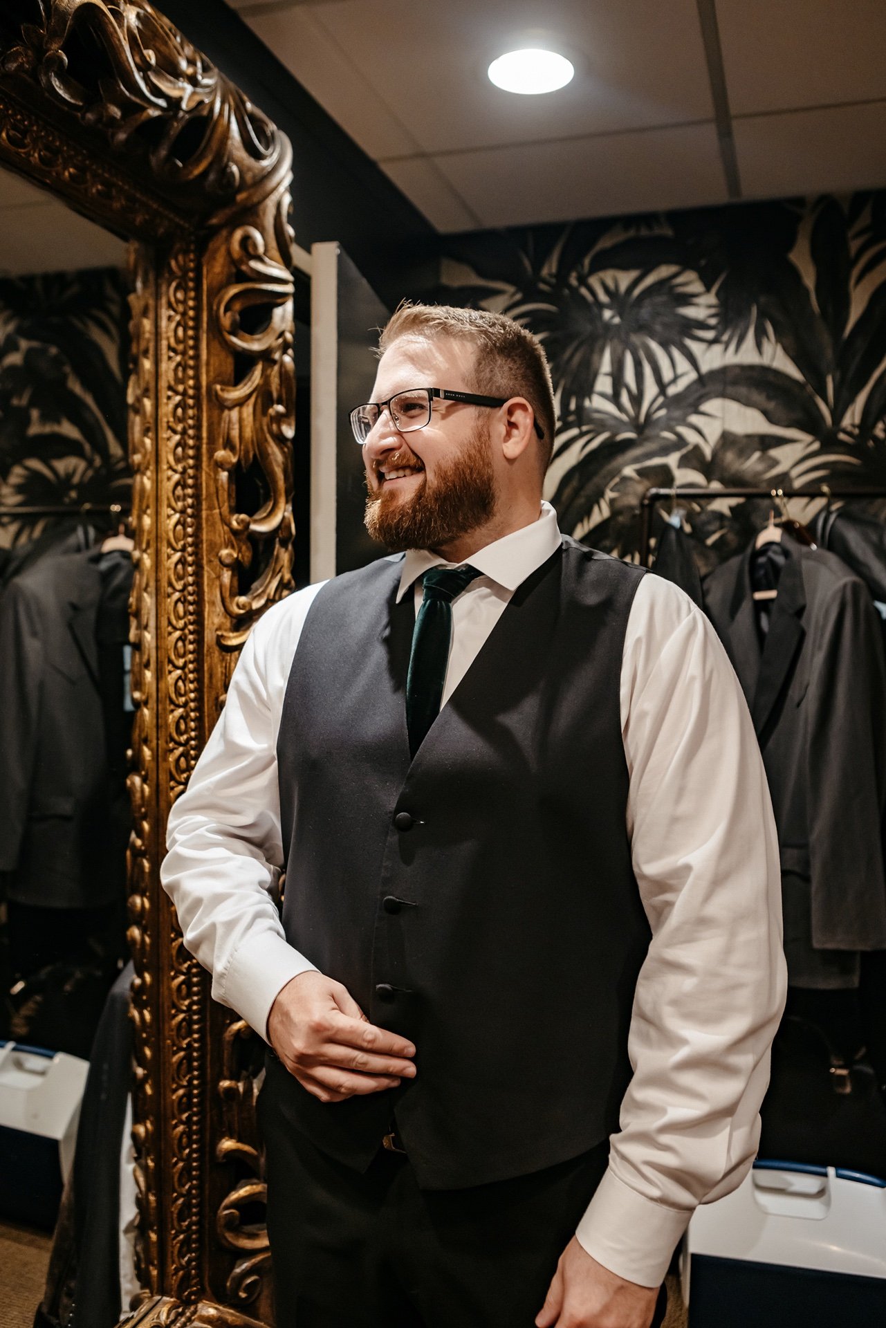 A groom in a tuxedo smiles as he prepares for his wedding in Central Florida